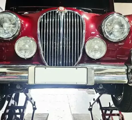 A classic car in the garage symbolizes the dedication and craftsmanship that goes into preserving automotive history.